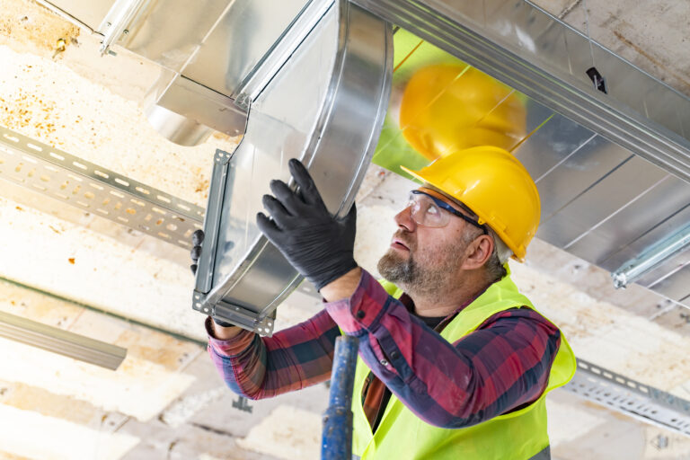 technician setting up ventilation system indoors