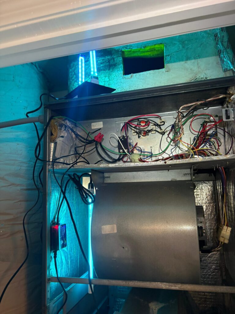 Open HVAC air handler showing the blower motor and wiring wider perspective in Holiday FL